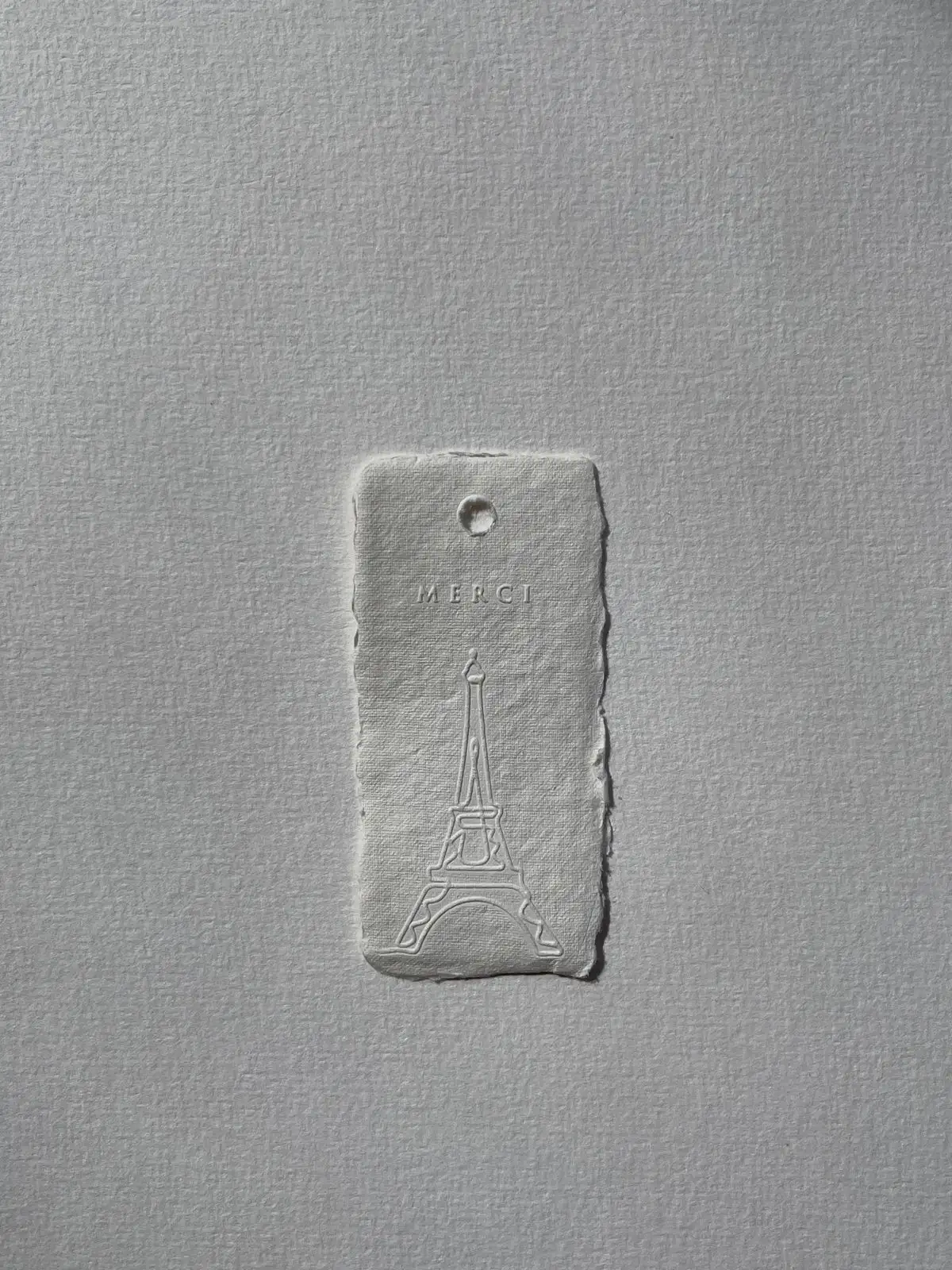 Etiqueta blanca con dibujo en relieve